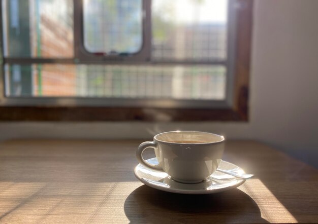 Filiżanka gorącej kawy na drewnianym stole.