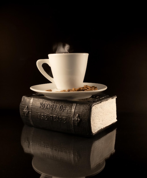Filiżanka gorącej kawy z ziaren kawy na książce