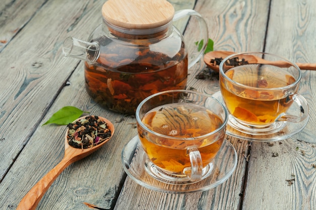 Filiżanka herbata i herbaciani liście na drewnianym stole