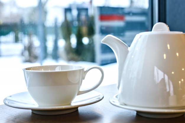 Filiżanka herbata i teapot na drewnianym stole w restauraci