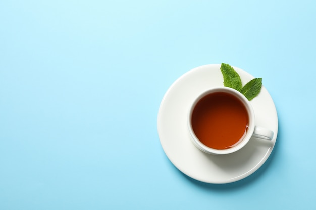 Filiżanka herbaty i mennicy liście na błękicie, kopii przestrzeń