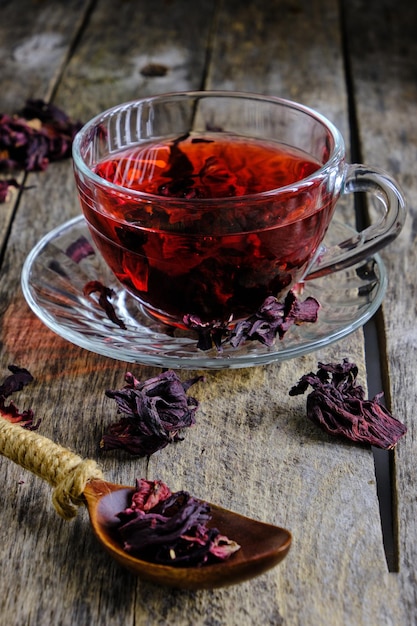 Zdjęcie filiżanka herbaty karkade z drewnianym tłem w jasnym czerwonym odcieniu