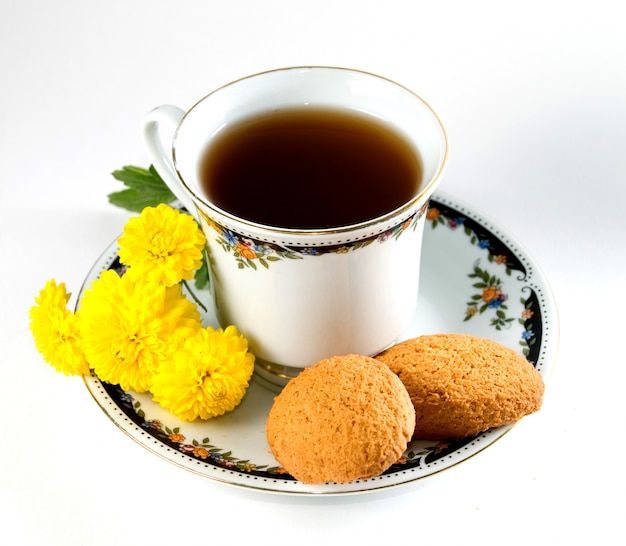 Filiżanka herbaty z ciasteczkami i kwiatami