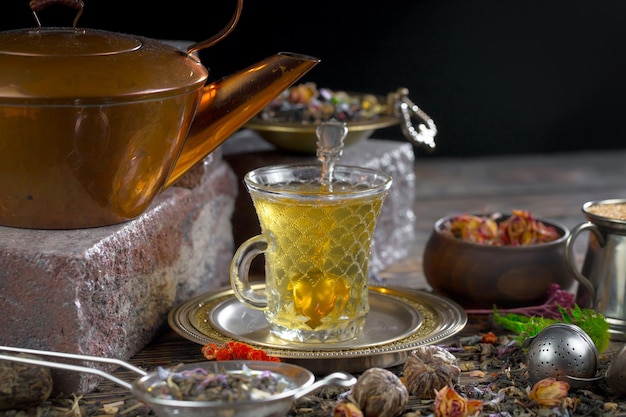 Filiżanka herbaty z czajnikiem i czajnikiem z zielonym liściem.
