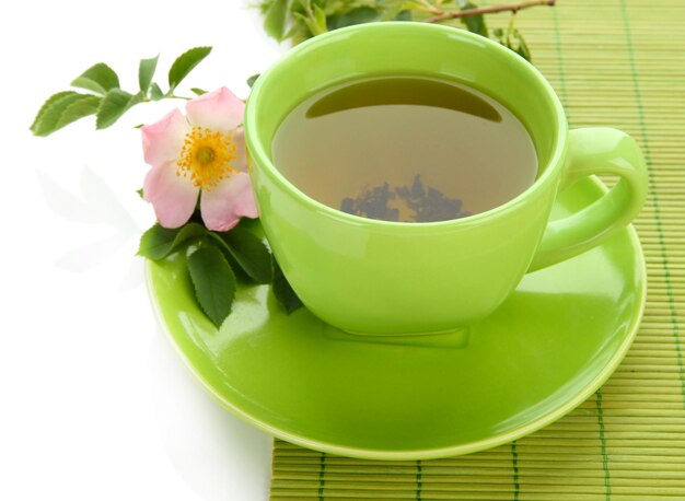 Filiżanka herbaty ziołowej z kwiatem róży na białym tle