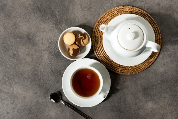 Filiżanka i czajnik z białej porcelany, angielska herbata na stole, popołudniowa herbata