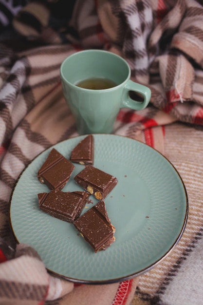 Zdjęcie filiżanka i talerz z herbatą, zielony. czekolada jest na talerzu