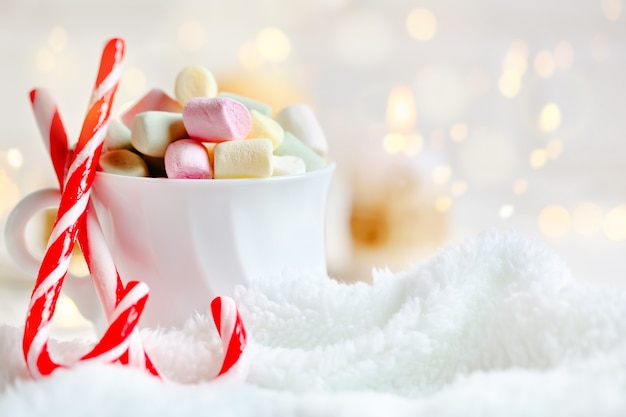 Filiżanka kakao i marshmallows na lekkim tle