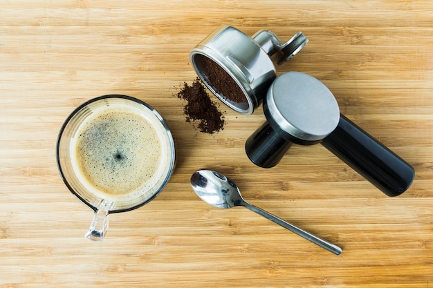 Filiżanka kawa espresso na drewnianej desce z zmieloną kawą