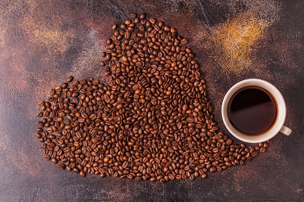 Filiżanka kawy i ziaren kawy nalewana w formie serca