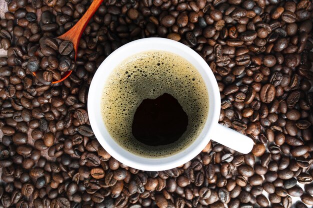 Filiżanka kawy na ziarnach kawy i niewyraźne tło Koncepcja żywności i napojów Kopiowanie przestrzeni