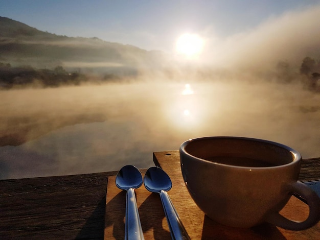Zdjęcie filiżanka kawy przy wodzie na tle nieba