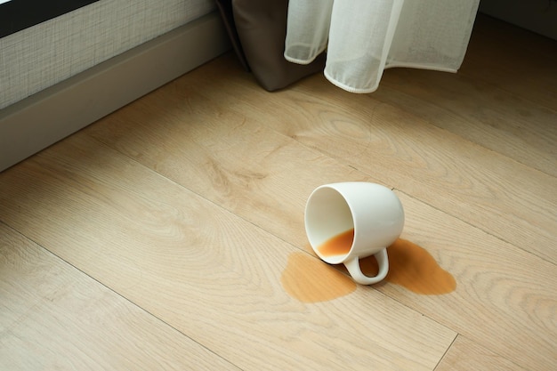 Filiżanka kawy rozlana na podłodze
