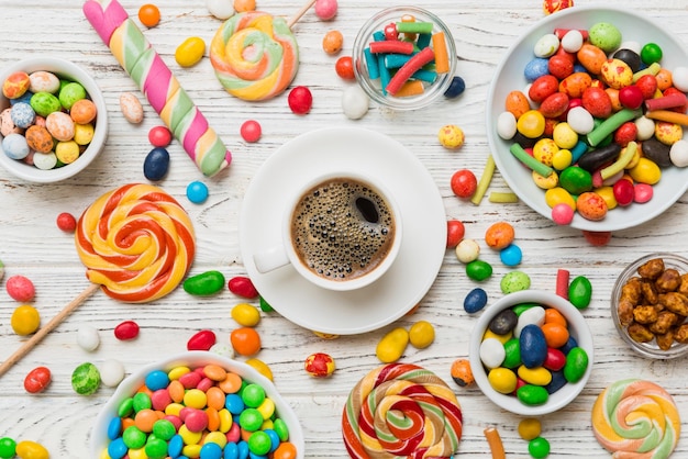 filiżanka kawy z czekoladami i kolorowymi cukierkami Górny widok na tle stołu z przestrzenią do kopiowania