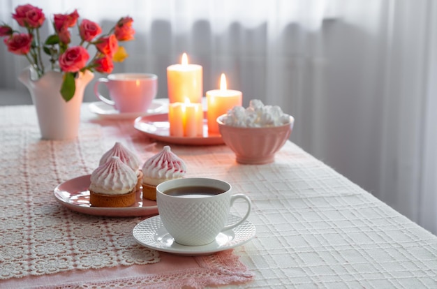 filiżanka kawy z deserem i róże na stole