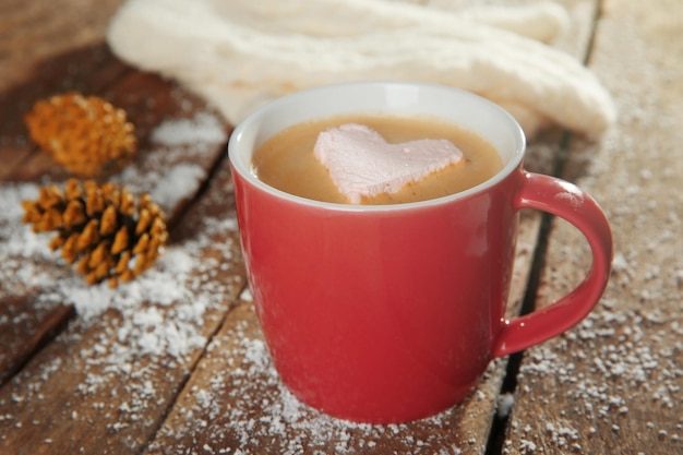 Filiżanka kawy z marshmallow na drewnianym stole