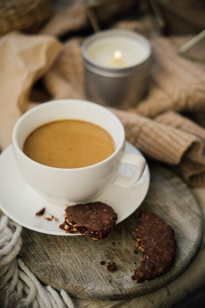 Filiżanka kawy z mlecznymi i czekoladowymi ciasteczkami na ciepłym wełnianym kocu