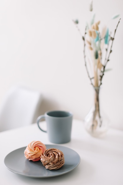 Filiżanka kawy z piankami i kwiatami na stole