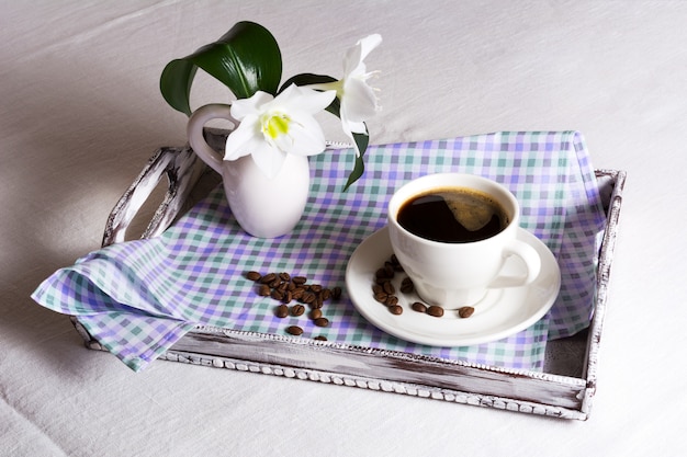 Filiżanka porannej kawy z białymi kwiatami
