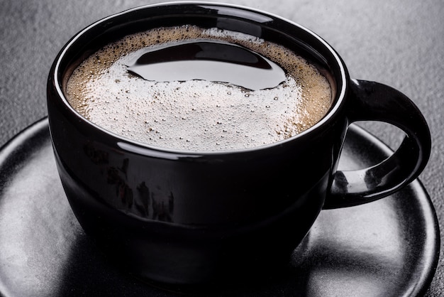 Zdjęcie filiżanka świeżo pachnącej porannej kawy zapewni radosny początek dnia. piękna filiżanka kawy z kawą na ciemnym stole