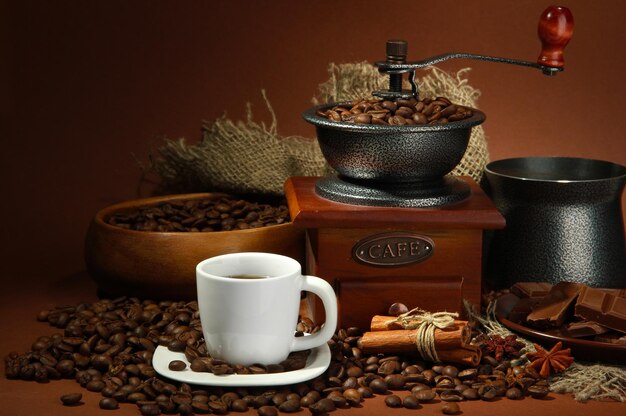 Filiżanka tureckiego młynka do kawy i ziaren kawy na brązowym tle
