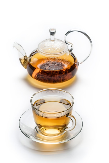 Filiżanka z herbatą i imbryk na białym tle na białej powierzchni