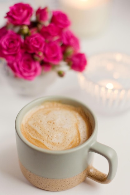 Filiżanka z kawą i różowymi kwiatami