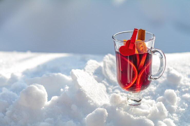 Zdjęcie filiżanka z pysznym grzanym winem i przyprawami na tle pokrytym śniegiem
