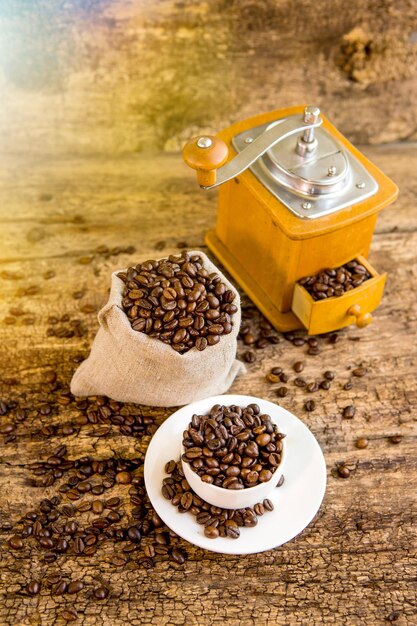 Filiżanka ziaren kawy Młynek do kawy i torebka z ziarnami kawy w tle Kawa Ziarna kawy