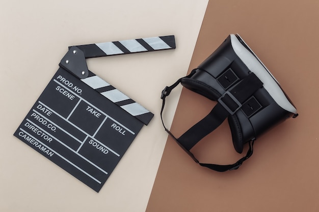 Film clapper board i zestaw wirtualnej rzeczywistości na beżowym brązowym tle. Produkcja filmowa, przemysł rozrywkowy. Widok z góry