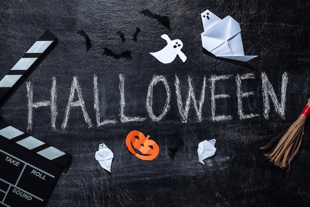 Film Clapperboard i napis Kredą Halloween na tablicy kredowej z wystrojem helloween. Motyw Halloween