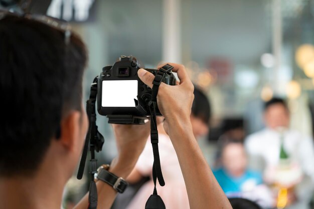 Filmowiec z tyłu kamery nagrywa i nagrywa wideo podczas imprezy weselnej