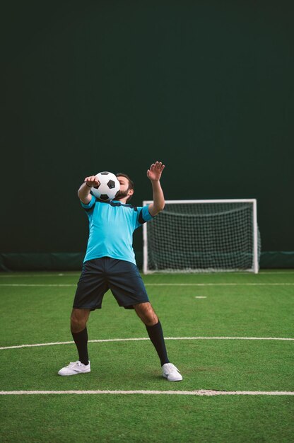 Filmowy obraz gracza w piłkę nożną freestyle wykonującego sztuczki z piłką