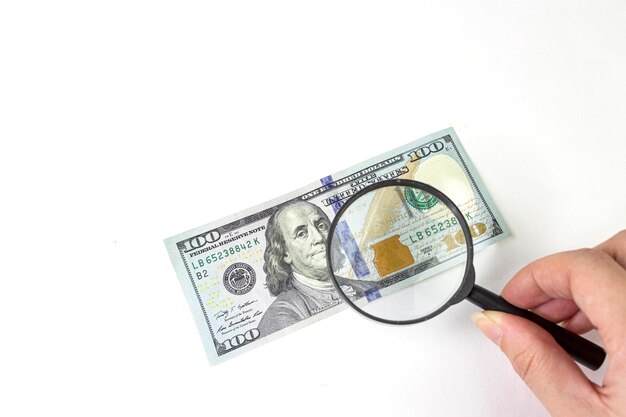 Finanse i biznes Zdjęcie zbliżenia z lupą na banknotach 100 dolarowych