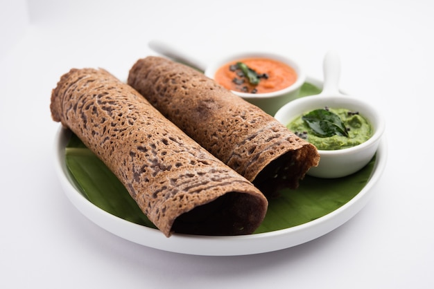 Zdjęcie finger millet lub ragi dosa to zdrowe śniadanie indyjskie podawane z chutney, w bułce, płaskiej lub w kształcie stożka