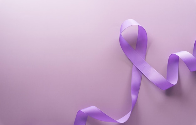 Fioletowa wstążka na tle pastelowego papieru za wsparcie kampanii Światowego Dnia Walki z Rakiem 4 lutego