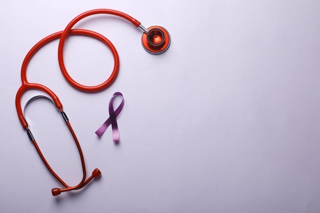 Fioletowa wstążka ze stetoskopem na dzień świadomości raka