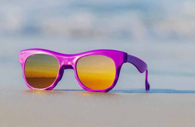 Zdjęcie fioletowe modne okulary przeciwsłoneczne na pięknej letniej plaży