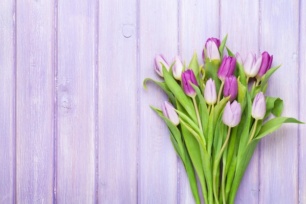 Fioletowe tulipany na drewnianym stole