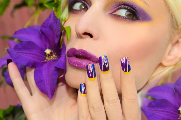 Fioletowy makijaż i manicure na dziewczynie z powojnikami