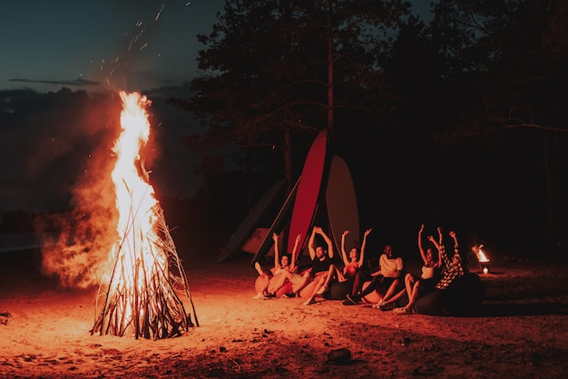 Firma siedzi przed ogniskiem na plaży