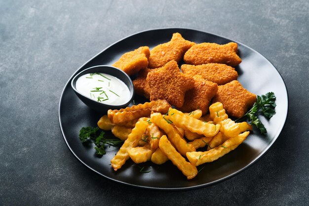 Fish Chips Brytyjskie Fast Food Paluszki Rybne z frytkami na czarnym talerzu na czarnym tle stołu Tradycyjne brytyjskie autentyczne jedzenie uliczne lub jedzenie na wynos Makieta z miejscem na tekst