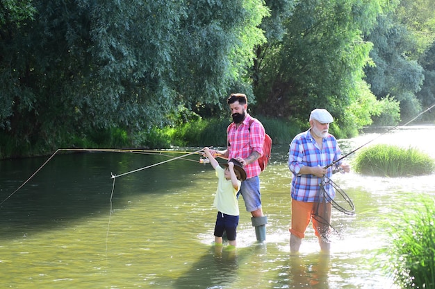 Fishing Wnuk z ojcem i dziadkiem łowiący ryby nad jeziorem Koncepcja pokolenia rodziny i ludzi Rodzinni rybacy łowiący na kołowrotku