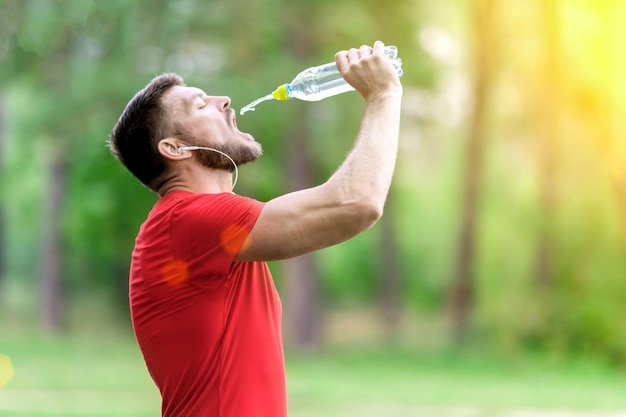 Fitness człowiek pije wodę z butelki