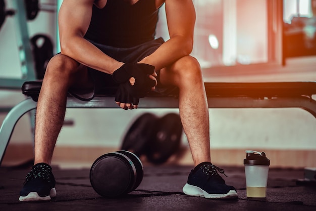 Fitness człowiek trenuje na siłowni. Wygląd ćwiczący ramiona treningowe w zdobywaniu siłowni.