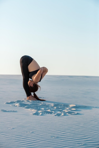 Fitness joga kobieta rozciągająca się na piasku pasuje lekkoatletka robi pozę jogi