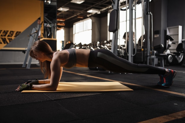 Fitness kobieta robi ćwiczenia deski, trenując jej siłę rdzenia