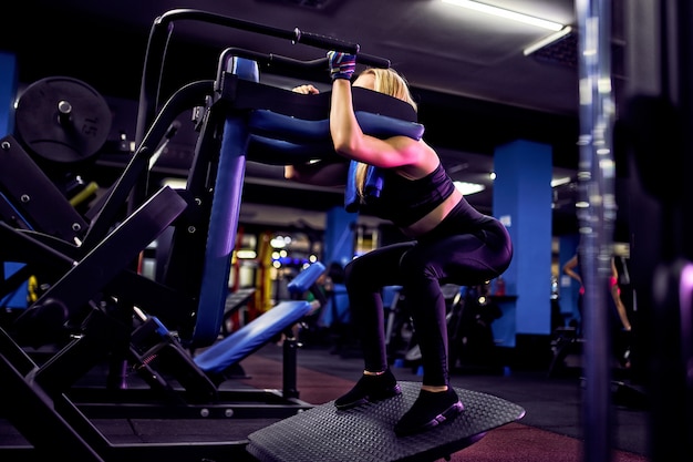 Fitness kobieta robi rzuca ćwiczenia na trening mięśni nóg, trening w siłowni