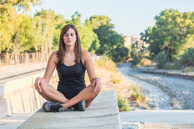 Fitness młoda kobieta ćwiczy jogę i medytuje w pozycji lotosu