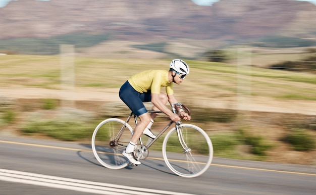 Fitness na rowerze i mężczyzna z rowerem na prędkości drogowej i rozmycie ruchu rowerzysty na zewnątrz i kask dla bezpieczeństwa Makieta kosmicznego sportowca i trening do ćwiczeń wyścigowych na wsi z rowerem